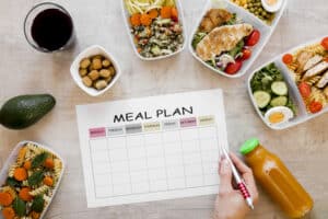 close up hand doing keto meal prepping and planning 