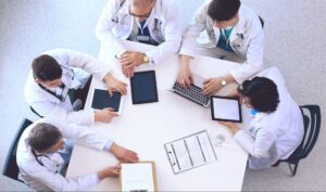 healthcare professionals on the table discussing the importance of a Collaborative Approach to the Understanding and Management of Gluten Sensitivity