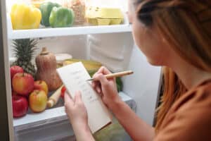 Young woman making a grocery shopping list