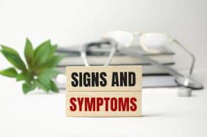 signs and symptoms words on wooden blocks and stethoscope
